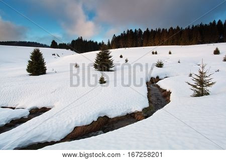 mountain river between snowy hills in winter