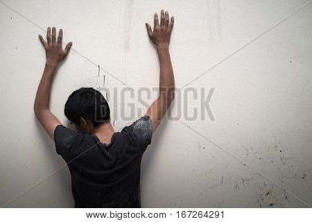 Man Show Hands Up Facing The Wall