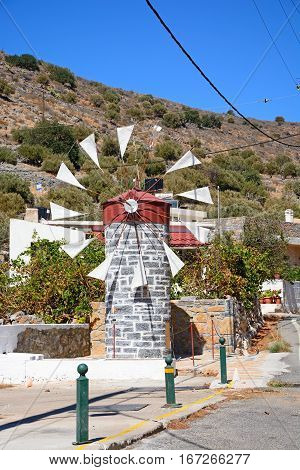 ELOUNDA, CRETE - SEPTEMBER 17, 2016 - Small stone windmill along a village street near Elounda Crete Greece Europe, September 17, 2016.