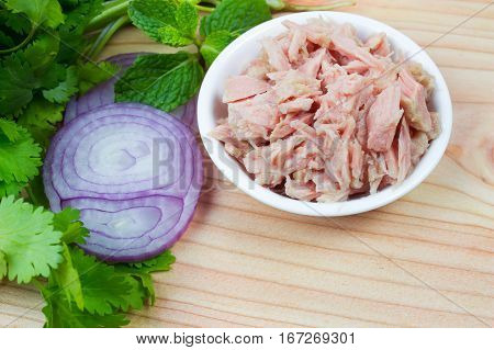 canned tuna on wood table / Canned albacore pink meat tuna packed in water