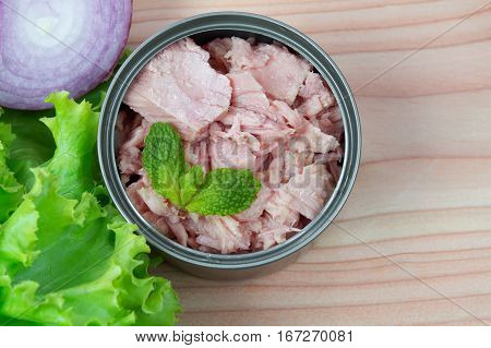 canned tuna on wood table / Canned albacore pink meat tuna packed in water
