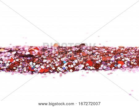 Copyspace backgdrop composition made of colorful and bright pile of sequins isolated over the white background