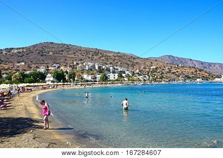 ELOUNDA, CRETE - SEPTEMBER 17, 2016 - View along the beach and coastline with tourists relaxing in the sunshine Elounda Crete Greece Europe, September 17, 2016.
