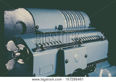 Old calculating machine isolated on black background
