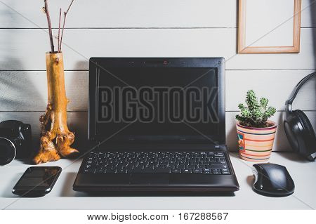 Laptop and gadgets on a white wooden table