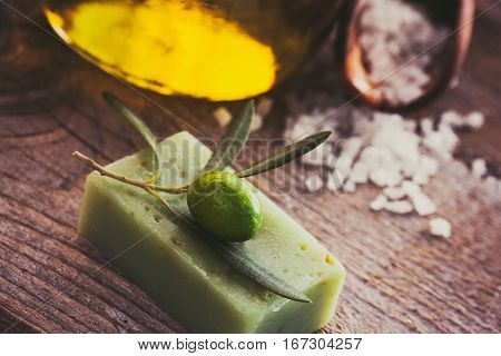 Natural spa setting with olive and olive oil products: bath salt natural soap and olive oil.