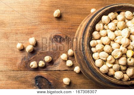 Portion of Chick Peas in wooden bowl top view.