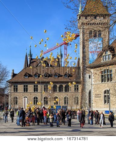 Zurich, Switzerland - 29 January, 2017: a group of people launching balloons bearing the symbolic of the C3 Church on the square at the entrance to the Swiss National Museum.