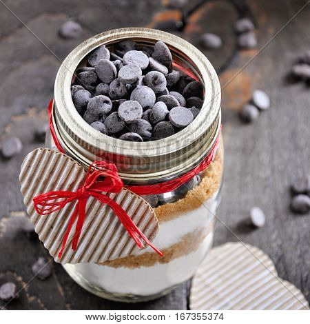 Cookie mix with chocolate chips in glass jar. St. Valentine's day gift concept selective focus toned image
