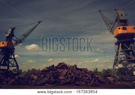 Metals recycling cranes with metal claws over heap