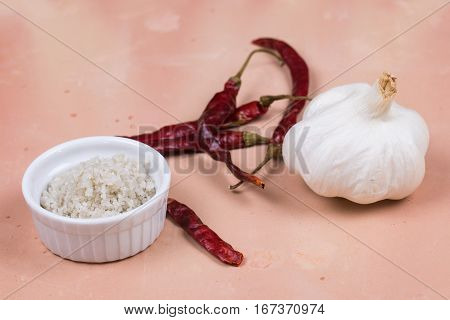 Gray Salt, Dried Red Peppers And Garlic On Saltillo Tile