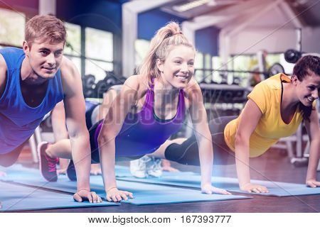 Fit people exersicing in plank position at gym