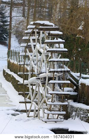Small Waterwheel In Frozen Creek In Park
