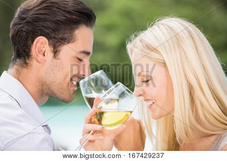 Close-up of couple drinking wine at poolside