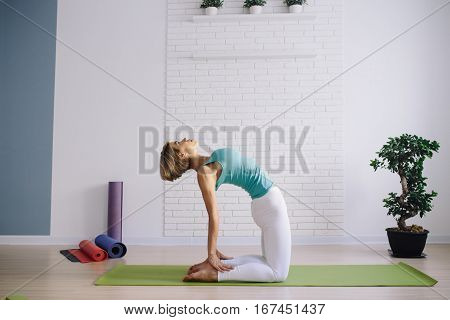 young girl in a blue t-shirt doing yoga at home. wellness concept