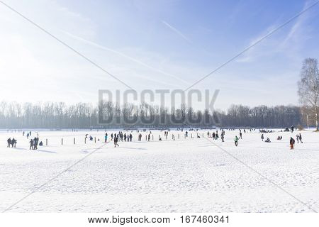 View on happy People on a frozen Lake. Different People on a sunny Winter Day.
Kuhsee in Winter. 
Augsburg - Germany
