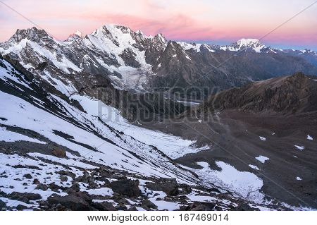Sunset in high snowy mountains. The view from the pass a bird's-eye view