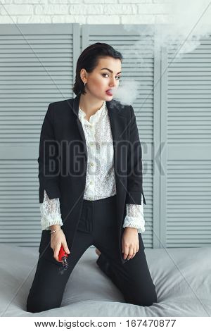 Woman with electric cigarette it is in a business suit.