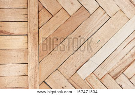 Close top view on rich texture of old brushed and distressed wooden parquet floor made from many racks in herringbone and simple row pattern on side, abstract background image