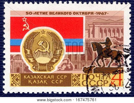 USSR - CIRCA 1967: post stamp printed in the USSR shows Coat of Arms, Flag and monument Kazakh SSR, serie 
