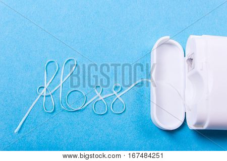 Dental floss word written in letters of floss on a blue background