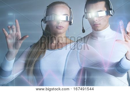 People in vr goggles touching a graph indicating growth on virtual display