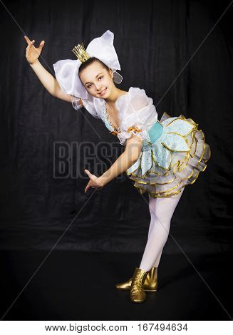 Gymnast is d pose doll on dlack background. Studio photography of circus performers.