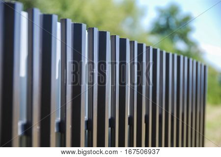Painted sheet metal planks forming a diagonal fence line