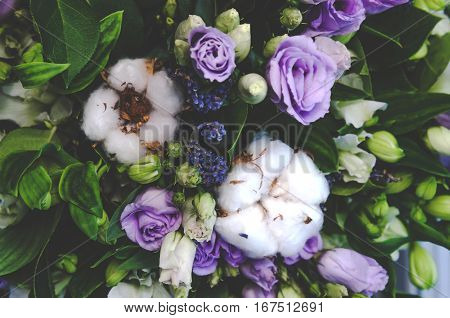 Delicate white ball cotton flower. Details of a bohemian bouquet of flowers. Winter floral composition green background.