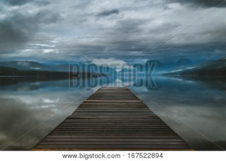 Dock overlooking a calm overcast lake in Montana.