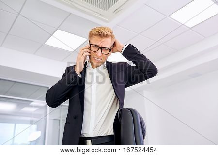 The concept stress business problems loser bankruptcy. Blond businessman talking on phone heard bad news.