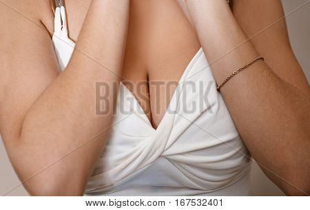 Shot of young woman decolette of big tits and hands on in white lingerie.