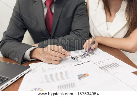 Businessman and woman discussing in business meeting with document on the table