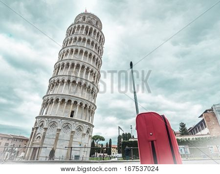 Italy Pisa tower with red hand luggage