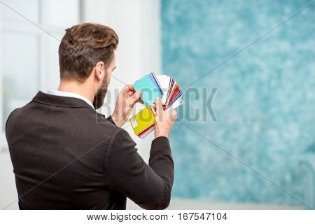 Elegant architect or designer choosing color for painting walls or apartment decotation from the color sample