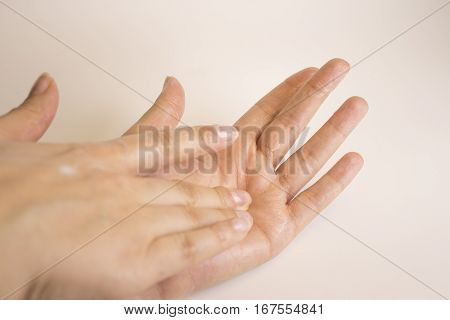 Hands of caucasian woman selfmassage with cream