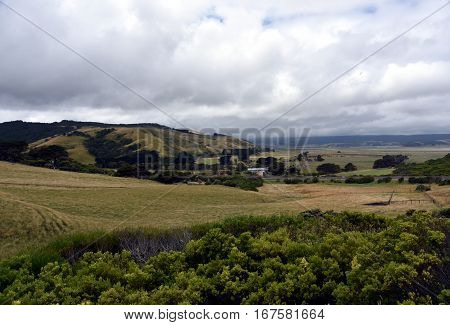 Broad panorama of the countryside in Victoria with green field in foreground. Grassy hills near Glenaire in Australia. Rural landscape near the forest in mountains. Hillside landscape.