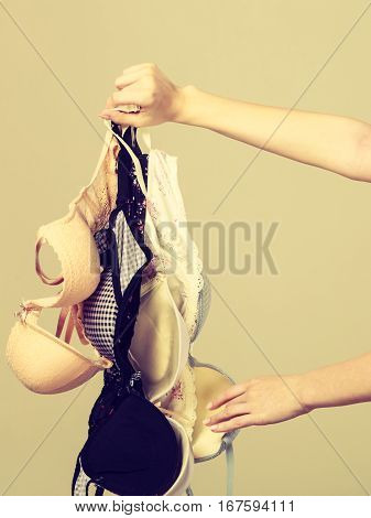 Female Hand With Many Bras To Wear