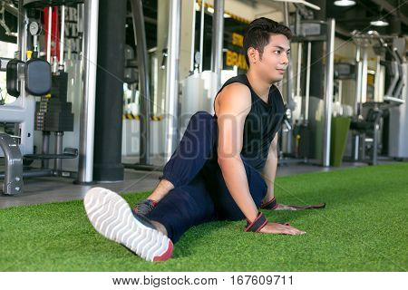Portrait of a man doing stretching exercises at gym.