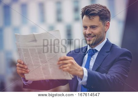 Close up of smiling businessman reading newspaper