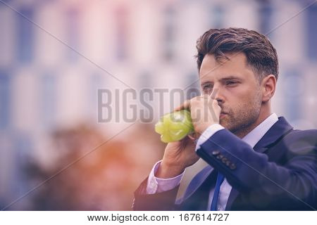 Close-up of handsome businessman drinking juice