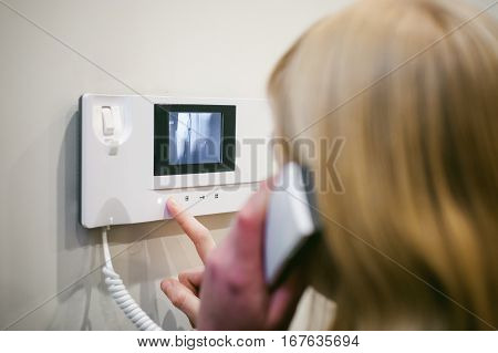 Blonde Woman Answers The Intercom Call While Holding The Phone To Your Ear