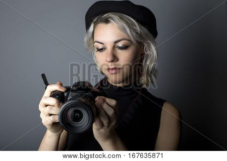 Female professional or amateur photographer holding a dslr camera. This photographic gear is used by both self employed artists and journalists or for tourism and hobbies.