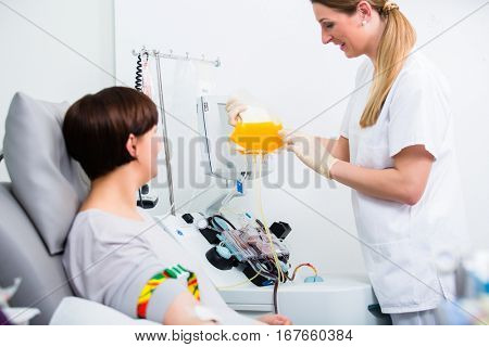 Nurse showing patient donating own blood in hospital her blood plasm