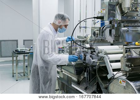 guy in white suit and gas mask check machines work
