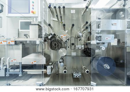 big machine under glass doors in pharmaciutical factory