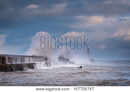 Cascading Waves over Tynemouth Pier, as a stormy sea hits it, resulting in high crashing waves cascading into the mouth of the River Tyne