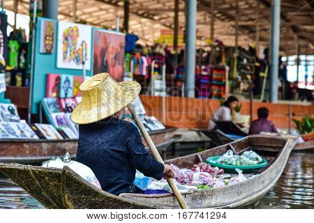 Bangkok / Thailand - January 20 2017: Old woman working with a boat in the floating market nearby to Bangkok