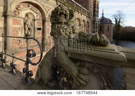 HILLEROD, DENMARK - DECEMBER 27, 2016: Sculpture of lion at the entrance to Frederiksborg Castle. It was built as a royal residence and becoming the largest Renaissance residence in Scandinavia