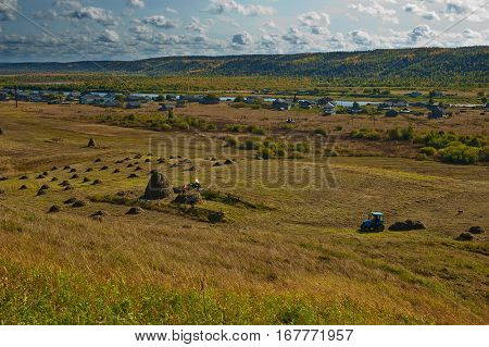 A haymaking in russian village. Beautiful fall landscape.